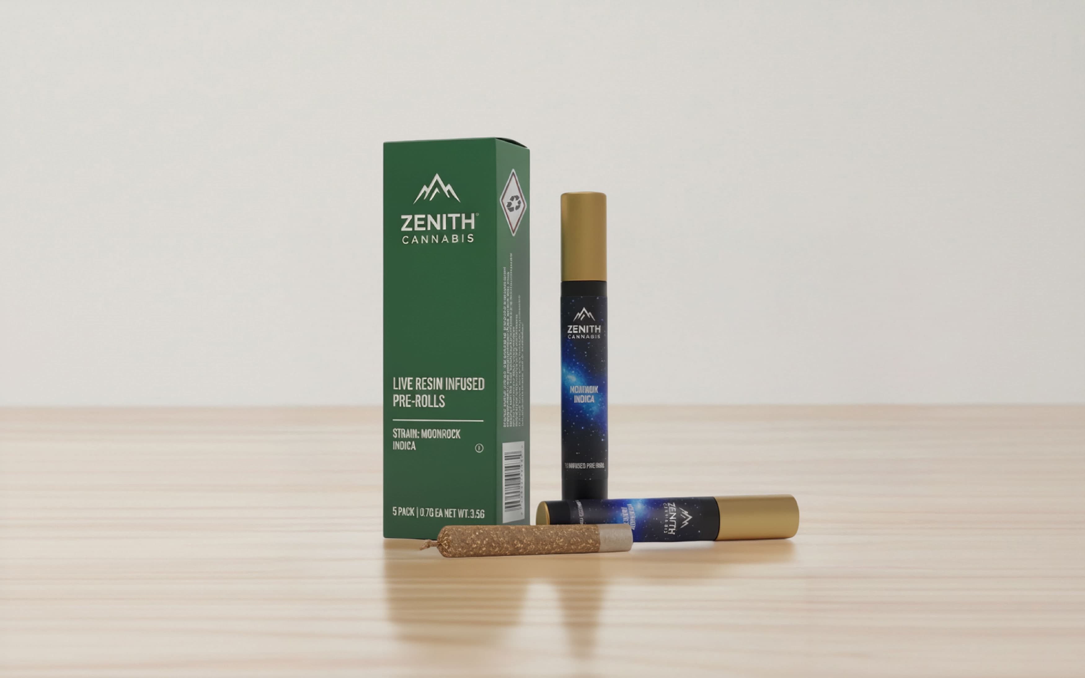 A green rectangular box for Zenith Cannabis Live Resin Infused Pre-Rolls stands on a wooden surface. The box indicates the strain is Moonrock Indica and contains a 5 pack. Next to the box is a slim, black pre-roll tube with a gold cap and a celestial blue nebula design, with another identical tube lying horizontally in the foreground