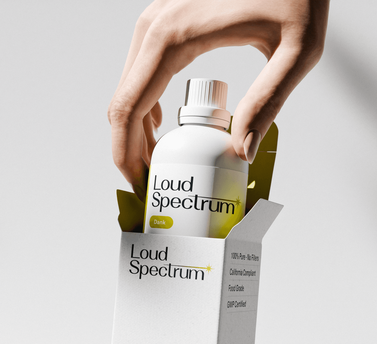 A pair of hands gently cradles a tall, textured light gray box against a plain white background. The packaging features the Loud Spectrum logo at the top and the word Dank printed vertically in a bold, metallic purple font. Text at the bottom reads Beyond Ordinary Terpenes and indicates a 50ml volume.
